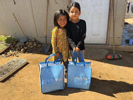 Two girls hold their new USANA bags