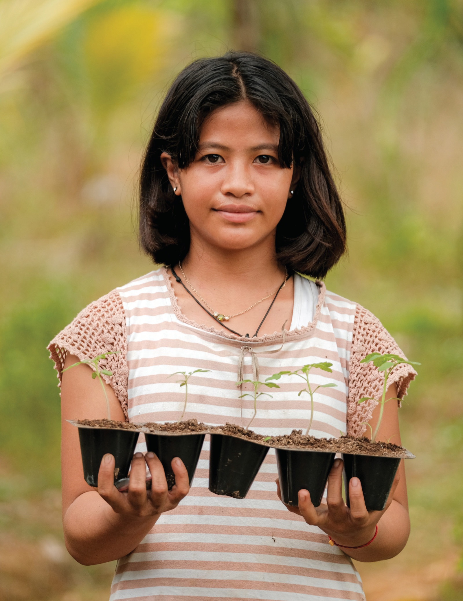 A girl on Guimaras Island holds a tray of seedlings