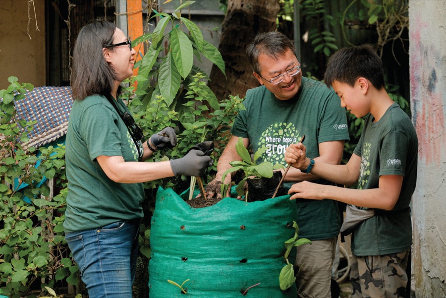 Volunteers fill a Garden Tower with soil