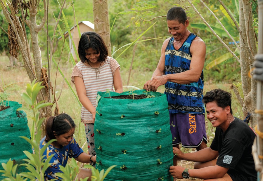 A family and volunteers beside finished Garden Towers