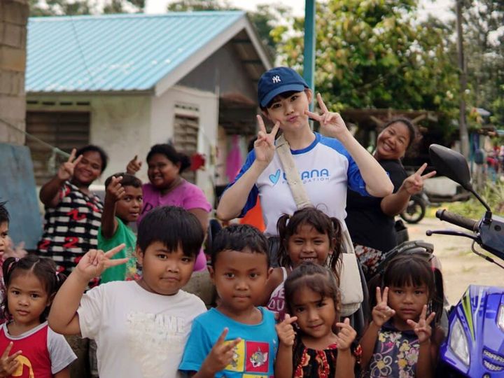 Smiling children gather with volunteers in a Malaysian village